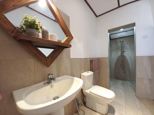 a bathroom with a sink and a toilet and a shower at Whispering Palms Retreat 