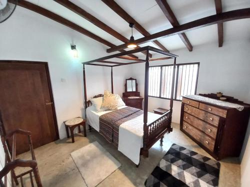 a bedroom with a canopy bed and a dresser at Whispering Palms Retreat 