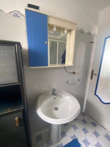 uma casa de banho com um lavatório e um armário azul em Casina Edomilla em Capri