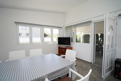 a dining room with a table and a television at Champions Apartmani in Kladovo