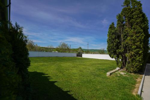 a large yard with a white fence and two trees at Champions Apartmani in Kladovo