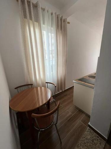 a room with a table and chairs and a kitchen at Perdja Apartment III in Velipojë