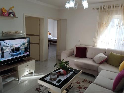 a living room with a couch and a tv at RONDO Guesthouse in Gjirokastër