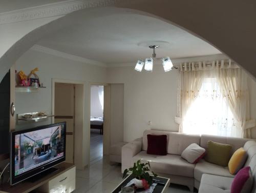 a living room with a couch and a television at RONDO Guesthouse in Gjirokastër