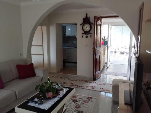 a living room with a couch and a clock on the wall at RONDO Guesthouse in Gjirokastër