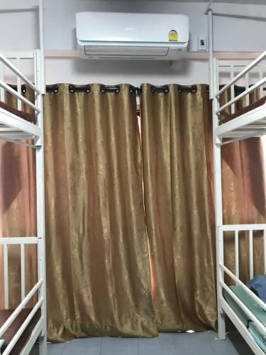 a bed room with a curtain and a heater at Grace Hostel in Khon Kaen