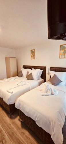 2 camas en una habitación con sábanas blancas en HOTEL FORMIO en París