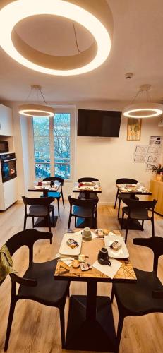 une salle à manger avec des tables et des chaises et un grand plafond dans l'établissement HOTEL FORMIO, à Paris