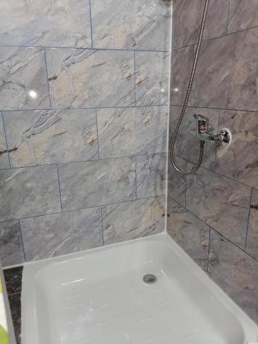 a bathroom with a shower with a tile wall at Cabañas Buen Recuerdo in Puyehue