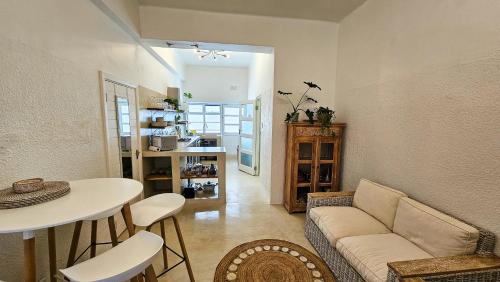 a living room with a couch and a table at Bali Beach Flats, Muizenberg in Cape Town