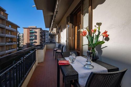 una mesa en un balcón con un jarrón de flores en Ferienwohnung für 4 Personen ca 98 qm in Sesto Fiorentino, Toskana Provinz Florenz, en Sesto Fiorentino