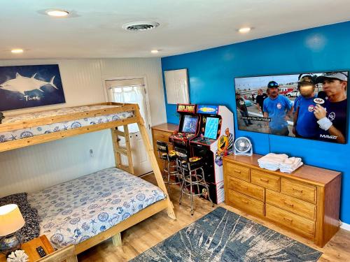 - une chambre avec des lits superposés et une télévision à écran plat dans l'établissement The Tiki House, à North Topsail Beach