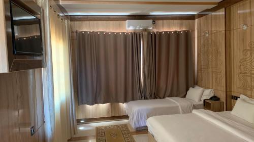 a hotel room with two beds and a window at Hotel Oasis Palace in Er Rachidia