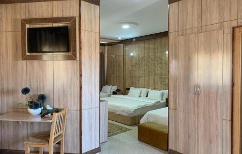 um quarto de hotel com duas camas e uma televisão em Hotel Oasis Palace em Er Rachidia