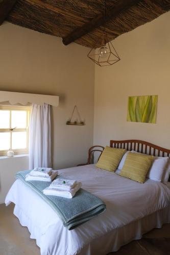 a bedroom with two beds with towels on them at Skooltjie Cottage in the Tankwa Karoo in Sutherland