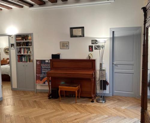 - un salon avec un piano et une étagère dans l'établissement Beautiful flat Seine River-Saint Michel/Notre-Dame, à Paris