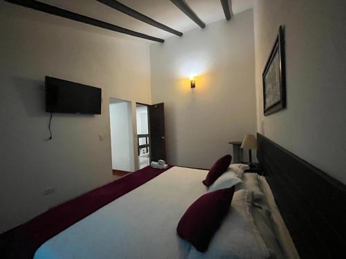 ein Schlafzimmer mit einem Bett und einem TV an der Wand in der Unterkunft VILLA LEWANA 2 in Villa de Leyva