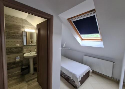 ヴァマ・ヴェケにあるVila Dini(La Rogojini)のバスルーム(ベッド1台、シンク、窓付)