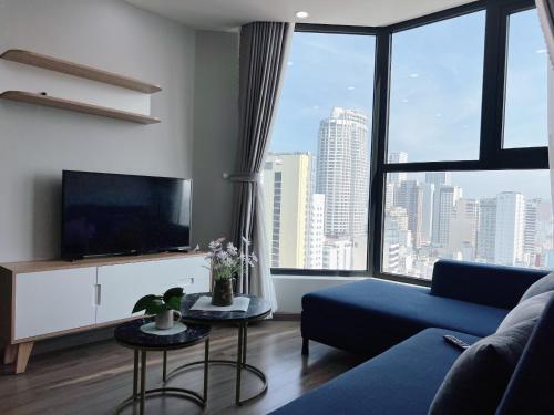 Una sala de estar con un sofá azul y una ventana grande. en Sea Horizon Apartment, en Nha Trang