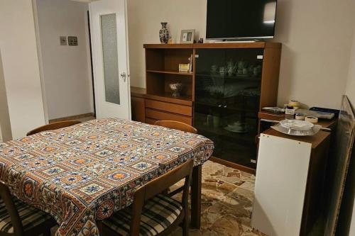 ein Esszimmer mit einem Tisch und einem TV in der Unterkunft casa vacanze Ugo e Betty in Sanremo