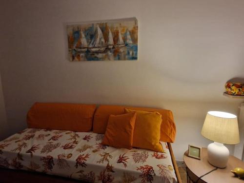 ein Schlafzimmer mit einem Bett und einem Tisch mit einer Lampe in der Unterkunft casa vacanze Ugo e Betty in Sanremo