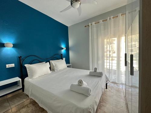 W Pearl Suite في ني بيراموس: غرفة نوم زرقاء مع سرير عليه مناشف