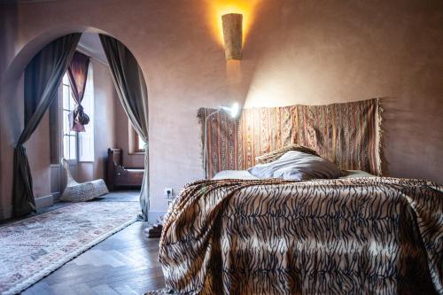 Dormitorio con cama con cabecero estampado en Boho Village Chateau in medieval bastide, en Chalabre