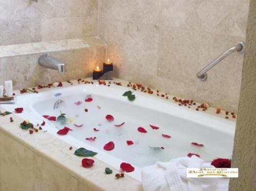 a bathroom with a tub filled with flower petals at Hacienda Real del Caribe Hotel in Playa del Carmen