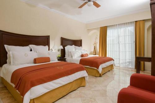 a hotel room with two beds and two lamps at Hacienda Real del Caribe Hotel in Playa del Carmen