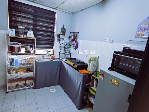 a small kitchen with a sink and a refrigerator at Homestay D'Lapang near KLIA in Sepang