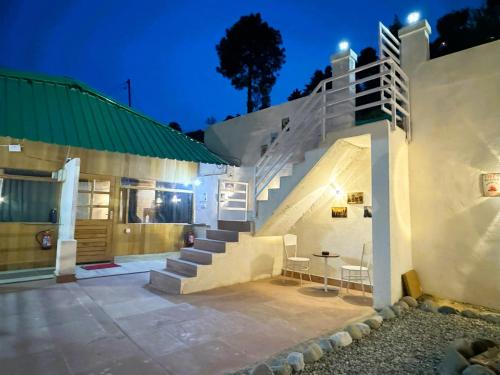 a house with a staircase leading up to a building at Wanderlust Mukteshwar in Mukteswar