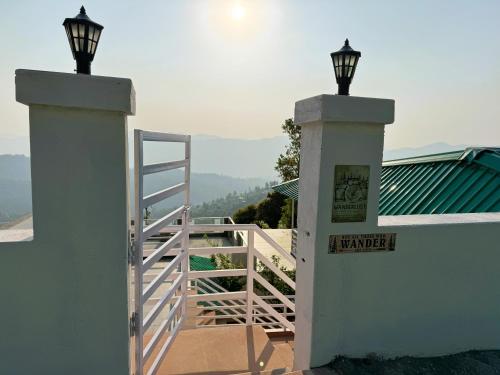 a white fence with a gate and a stairway at Wanderlust Mukteshwar in Mukteswar