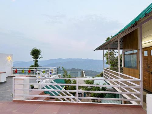 una casa con una recinzione bianca sul balcone di Wanderlust Mukteshwar a Mukteshwar