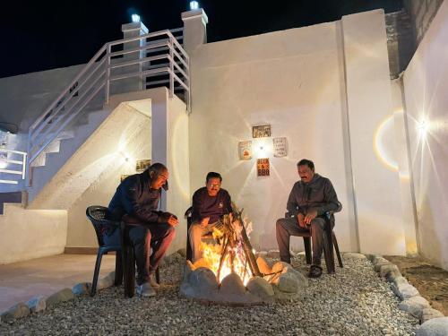 a group of people sitting around a fire at Wanderlust Mukteshwar in Mukteswar
