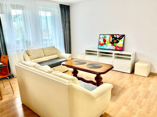 uma sala de estar com um sofá e uma mesa em Przytulny apartament em Augustów