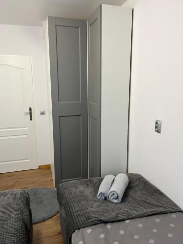 a bedroom with a bed with two towels on it at Przytulny apartament in Augustów