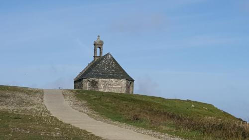 an old building on top of a hill with a path at Sur La Route Des Myrtilles in Gouézec