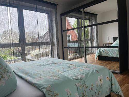 sypialnia z łóżkiem i dużymi oknami w obiekcie Apartments Vreden Familie Lansing w mieście Vreden
