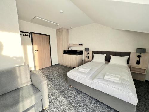 a bedroom with a large bed and a chair at SILVER BALTIC in Kołobrzeg