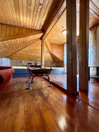 a large room with a wooden ceiling and a bench at Luylyana Guesthouse in Ribarica