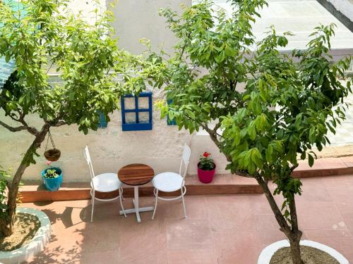 a table and two chairs and two trees at Wanderlust Mukteshwar in Mukteswar