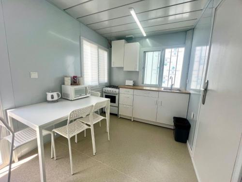 a kitchen with a white table and chairs in it at Grace Container homes in Cedar Grove