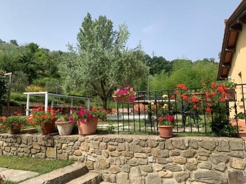 einen Garten mit Blumen in Töpfen auf einem Zaun in der Unterkunft Guest House Torre Guelfa in Figline Valdarno