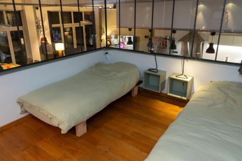 a room with two beds and two tables in it at Superbe loft de caractère avec garage à 10' du centre in Liège