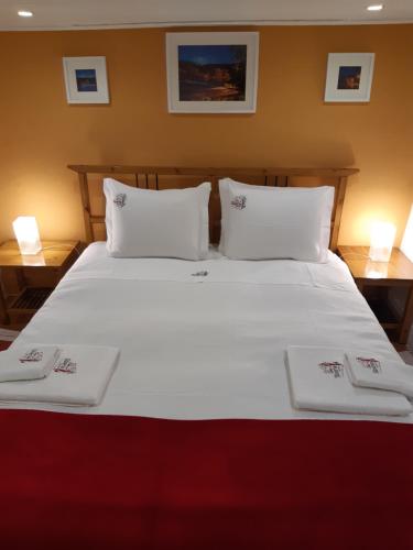 a large white bed with two white towels on it at Casa da Avó - Barroca in Barroca