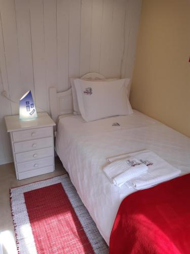 Habitación pequeña con cama blanca y mesita de noche en Casa da Avó - Barroca en Barroca
