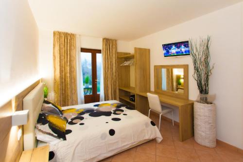 a bedroom with a bed and a desk and a mirror at Residence Delle Rose in Tremosine Sul Garda