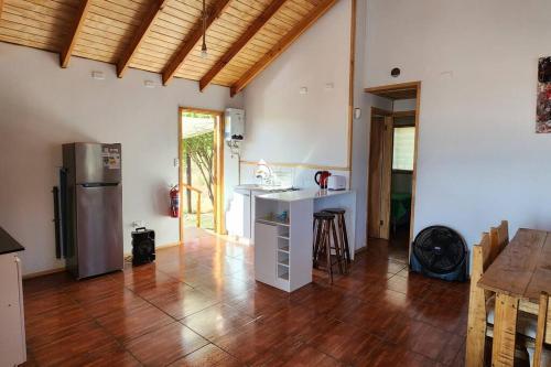 - une cuisine avec un comptoir, un réfrigérateur et une table dans l'établissement Cabaña descanso naturaleza, à Colbún