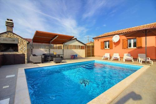 a swimming pool in the backyard of a house at Ferienhaus mit Privatpool für 5 Personen ca 80 qm in Loborika, Istrien Südküste von Istrien in Loborika