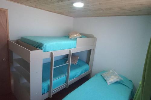 - une chambre avec 2 lits superposés et des draps bleus dans l'établissement Cabaña descanso naturaleza, à Colbún